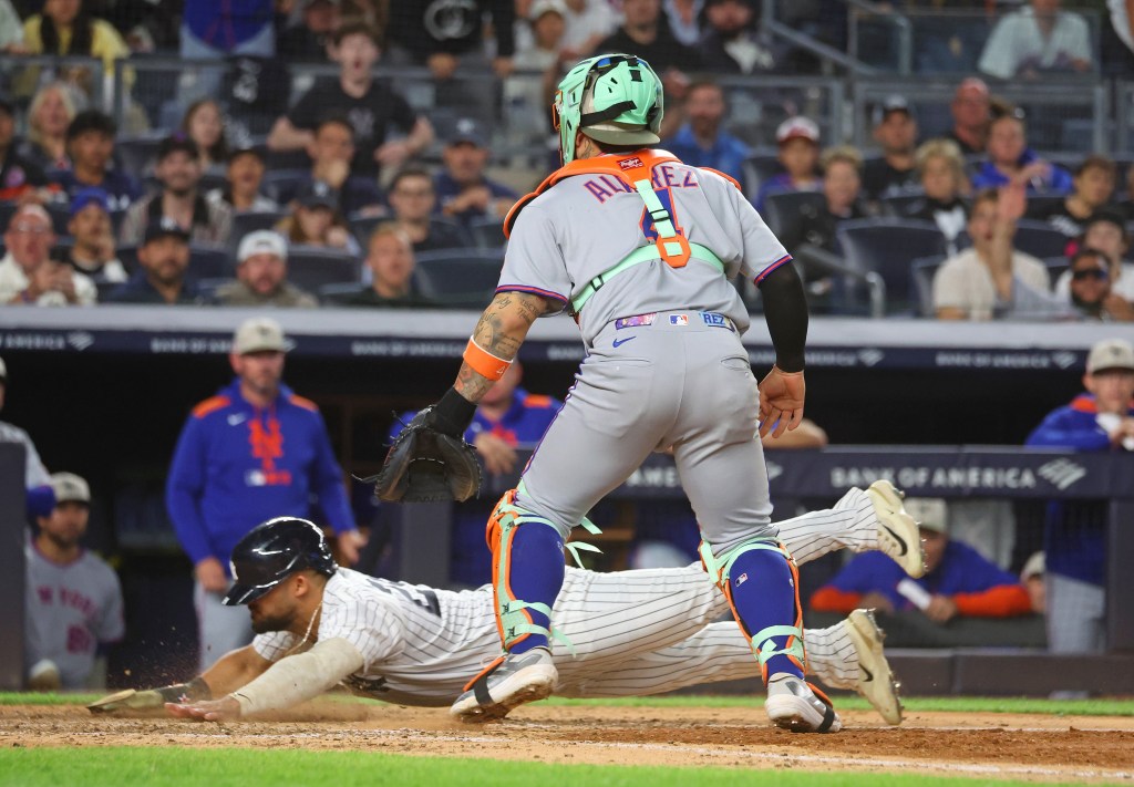 Jasson Domínguez of the New York Yankees scoring a run during a game against the New York Mets at Yankee Stadium.