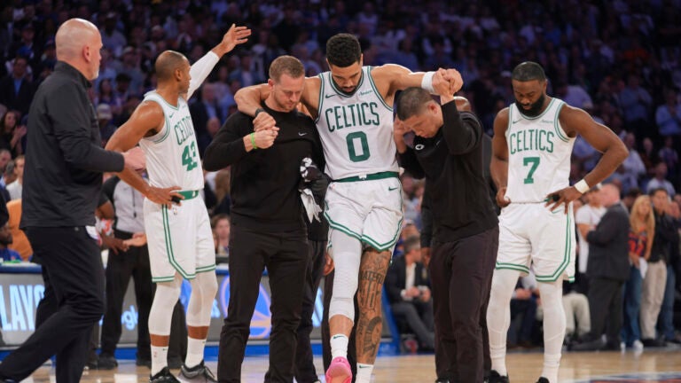 Trainers help Boston Celtics' Jayson Tatum (0) off the court after he was injured during the second half of Game 4 in the Eastern Conference semifinals of the NBA basketball playoffs against the New York Knicks Monday, May 12, 2025, in New York.