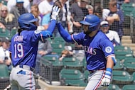 Texas Rangers' Jake Burger, right, is greeted by Alejandro Osuna, left, after hitting a...