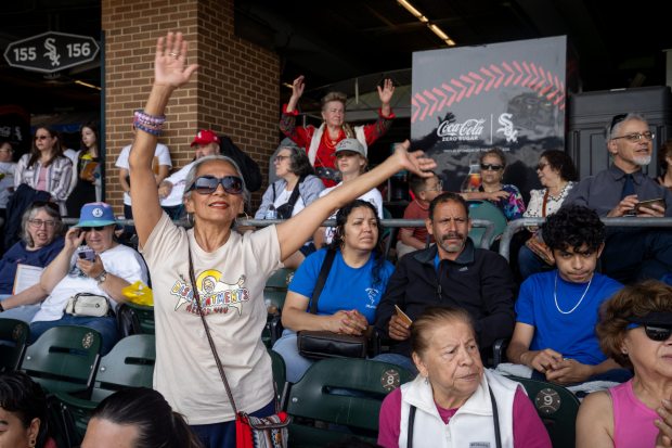 Mireya Robles waves her arms to a song during a citywide gathering at Rate Field, celebrating the election of Pope Leo XIV, on June 14, 2025, at Rate Field. (Audrey Richardson/Chicago Tribune)