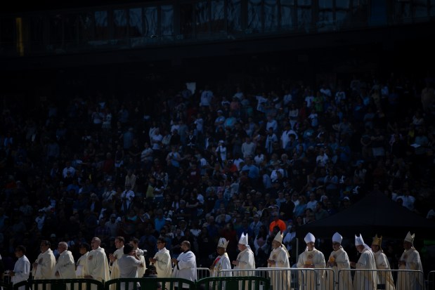 Priests walk onto the baseball field as a Catholic Mass begins while celebrating the election of Pope Leo XIV with a citywide gathering at Rate Field on June 14, 2025. (Audrey Richardson/Chicago Tribune)