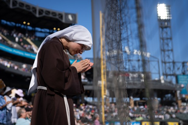 Sister Maggie Flynn, with Franciscans of the Eucharist of Chicago, participates in a Catholic Mass while celebrating the election of Pope Leo XIV with a citywide gathering at Rate Field on June 14, 2025. (Audrey Richardson/Chicago Tribune)
