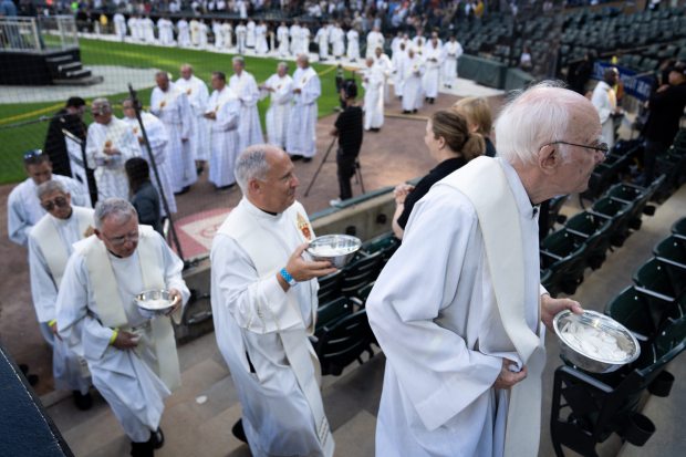 Priests make their way into the stands for the Communion at the end of a Mass at Rate Field on June 14, 2025. (Audrey Richardson/Chicago Tribune)