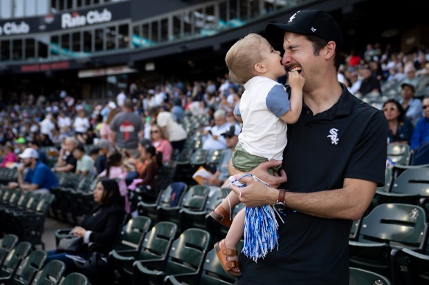 Joe Tomaselli and his son, Miles, 1, stand in the stands after a Catholic Mass took place while celebrating the election of Pope Leo XIV with a citywide gathering at Rate Field on June 14, 2025. (Audrey Richardson/Chicago Tribune)