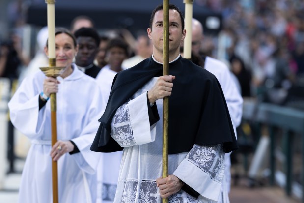 Priests walk off the baseball field at the end of a Catholic Mass while celebrating the election of Pope Leo XIV with a citywide gathering at Rate Field on June 14, 2025. (Audrey Richardson/Chicago Tribune)