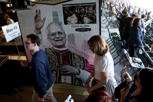 People walk by a mural of Pope Leo XIV, as hundreds gather to attend a mass and a celebration of the election of Pope Leo XIV, at Rate Field on June 14, 2025. (Antonio Perez/Chicago Tribune)